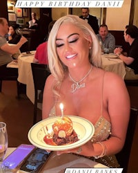 a woman is holding a cake at a restaurant